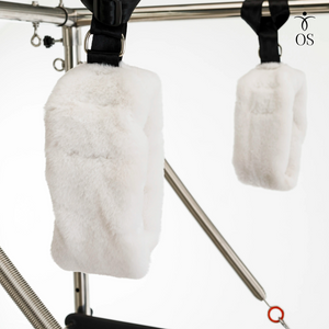 Padded Trapeze Swing bar featuring soft white wool "fuzzy" loops and red resistance springs on the Timber Cadillac Tower.