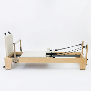 Side view of the Oshun Studios Timber Reformer in Maple showing the full solid wood Pilates reformer profile