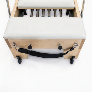 End view of the Oshun Studios Timber Reformer in Maple showing spring bar, foot strap, and wheels