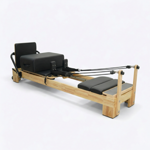 Angled view from the footbar end, showing the wide standing platform and padded footbar on the oak frame.