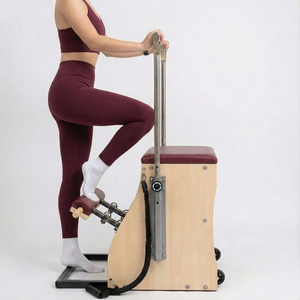 The Timber Chair by Oshun Studios: A solid wood split-pedal Pilates chair with black upholstery and adjustable handles.