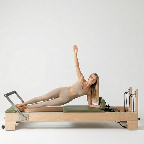 Woman exercising on a Pilates reformer machine against a white background