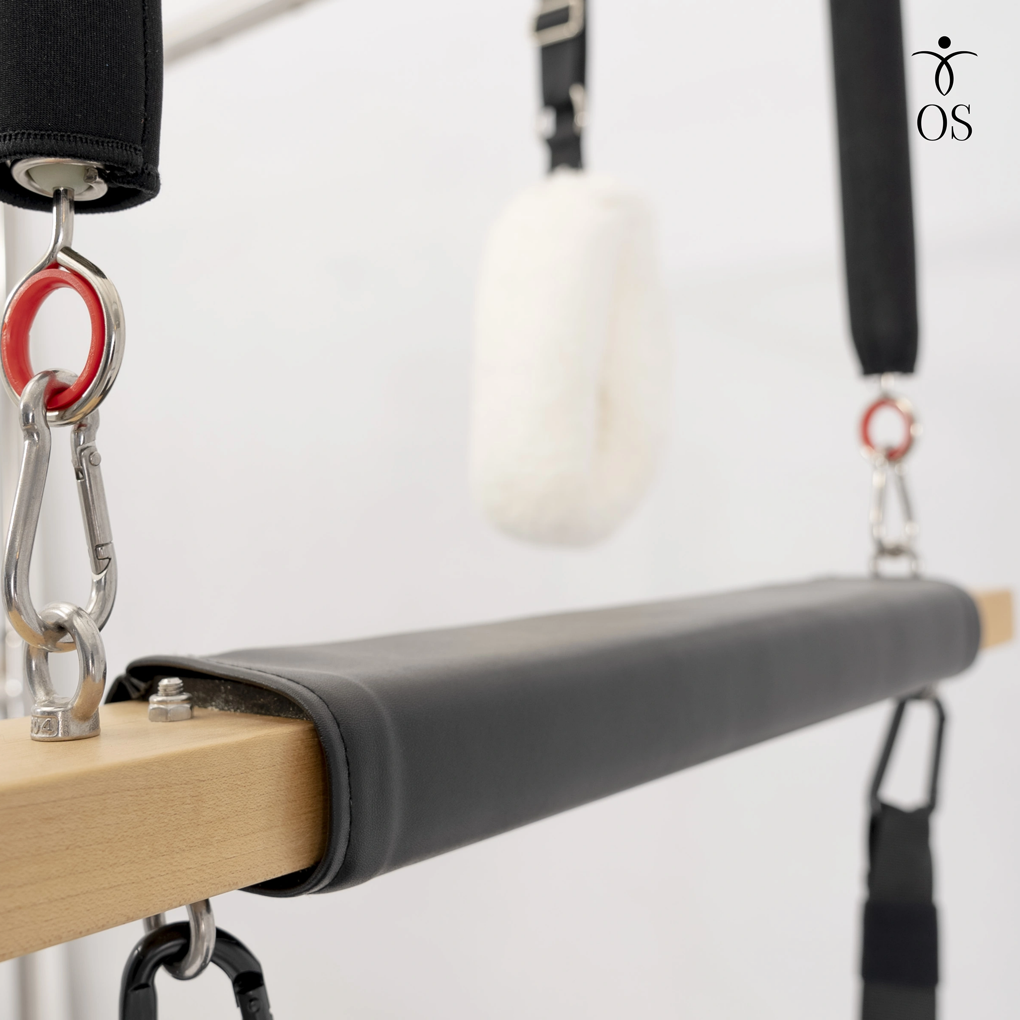 Padded Trapeze Swing bar featuring soft white wool "fuzzy" loops and red resistance springs on the Timber Cadillac Tower.