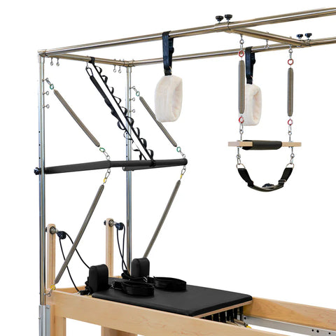 Pilates reformer machine with various attachments on a white background