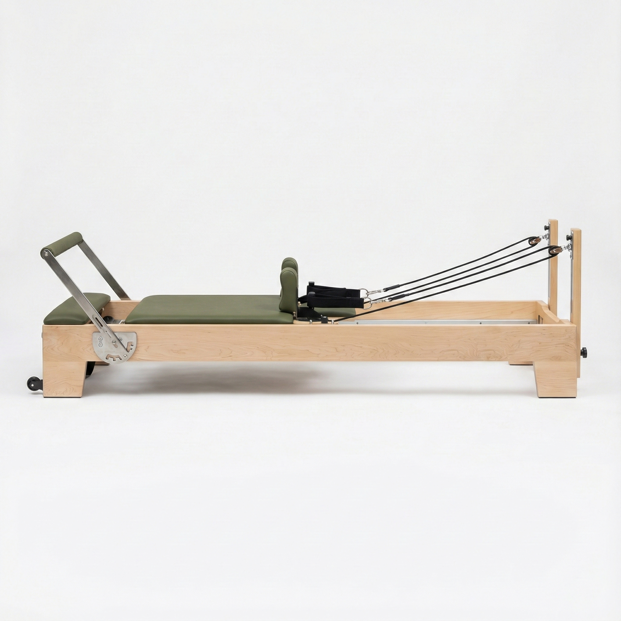 Pilates reformer with green cushion on a white background