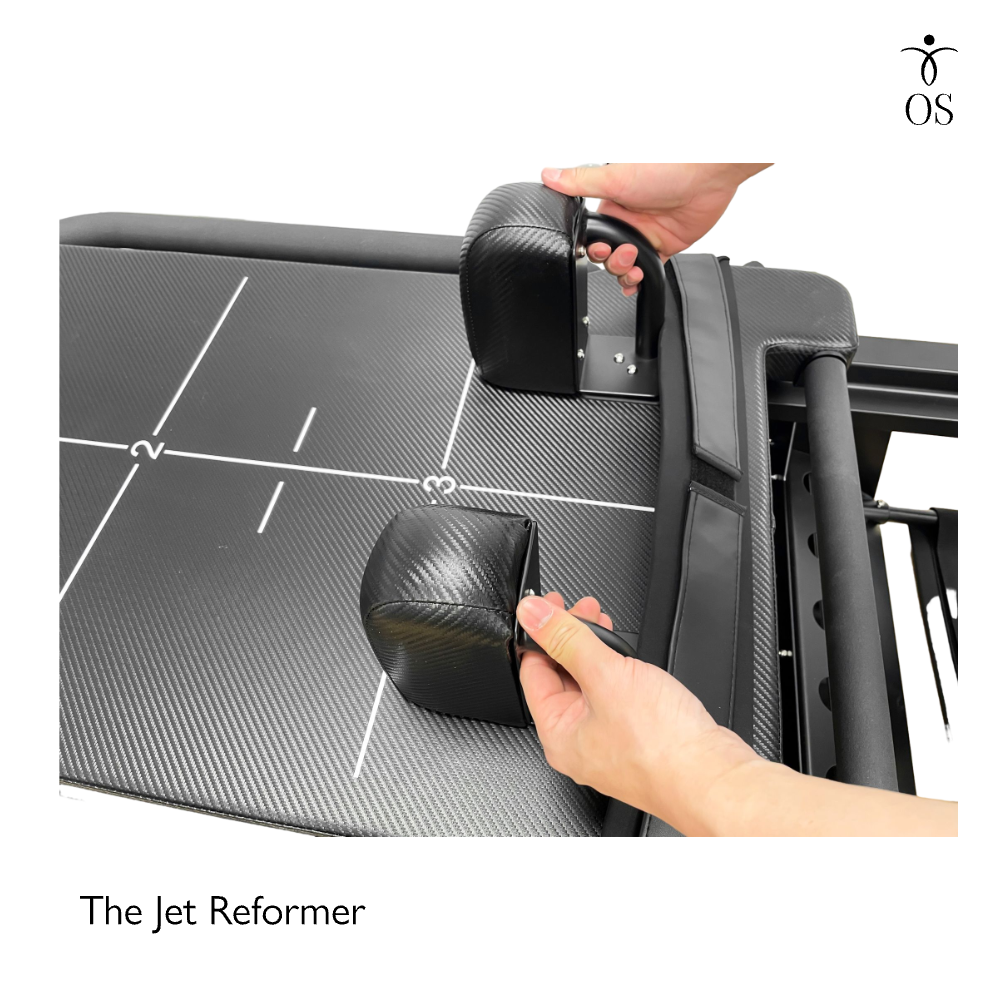 Adjustable padded headrest on the black Jet Reformer, providing essential neck support during high-intensity supine Pilates exercises.