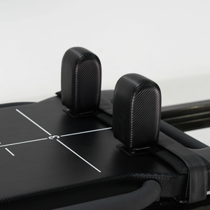 Padded adjustable headrest on the mega Reformer, shown in a raised position for neck support.