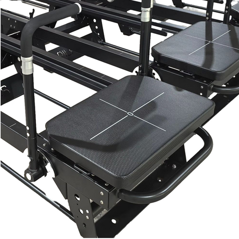 Extra-wide padded carriage on the Jet Reformer with grid markings for precise foot placement during lunges and planks.