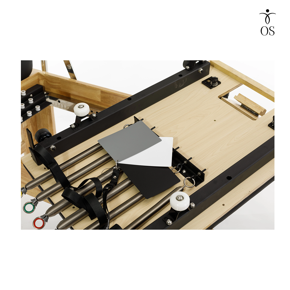 Underside view of the Timber Cadillac Reformer showing the heavy-duty rail system, precision carriage rollers, and solid wood bracing.