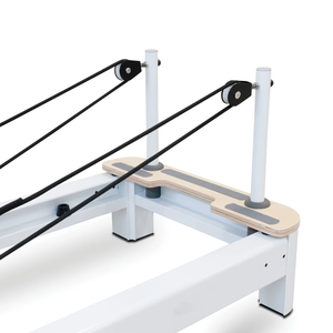Rope pulleys on the white uprights and wooden end deck of the Oshun Origin Reformer