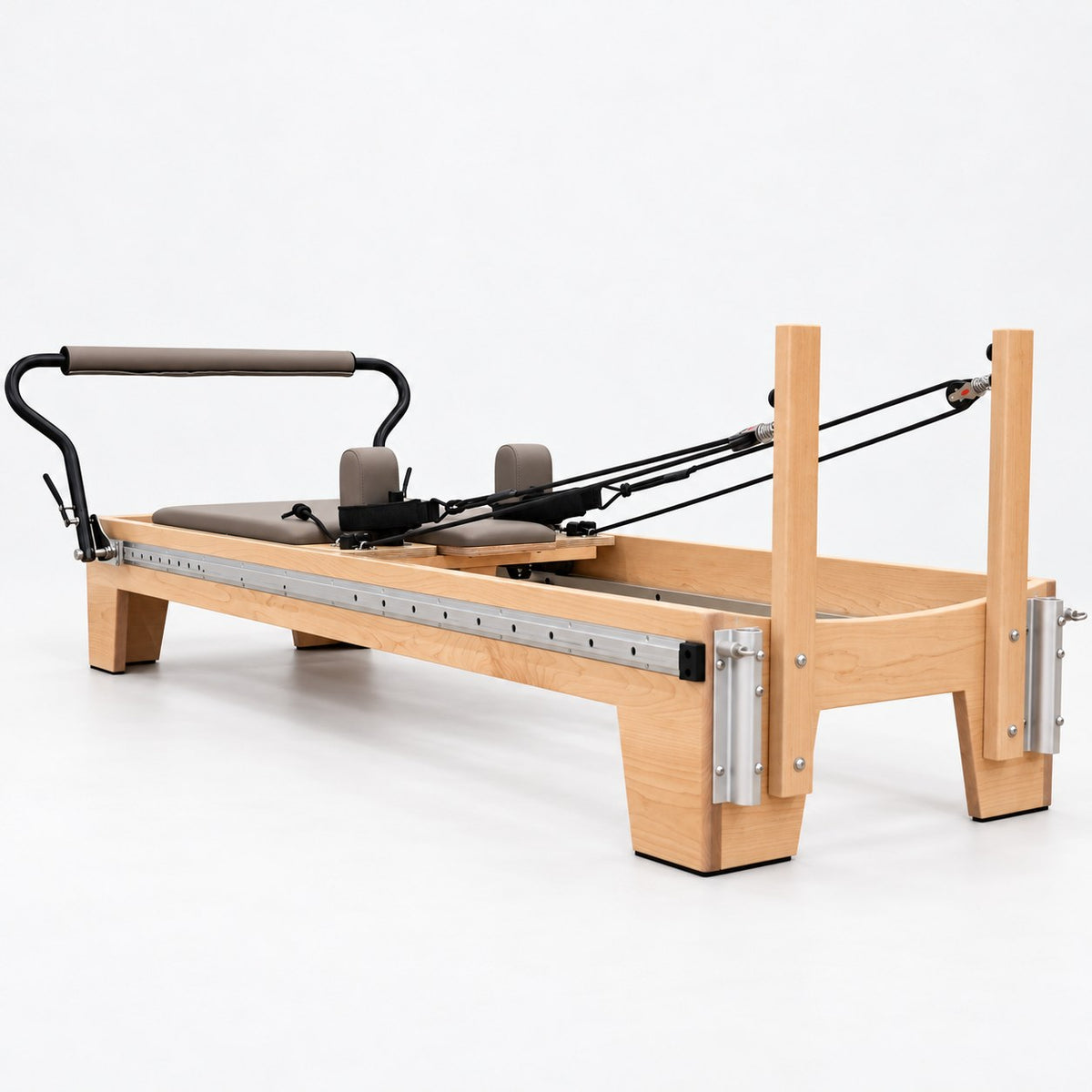 Head end of the Oshun Timber Therapy Reformer with maple risers and aluminum tower mounts