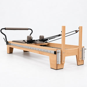 Head end of the Oshun Timber Therapy Reformer with maple risers and aluminum tower mounts
