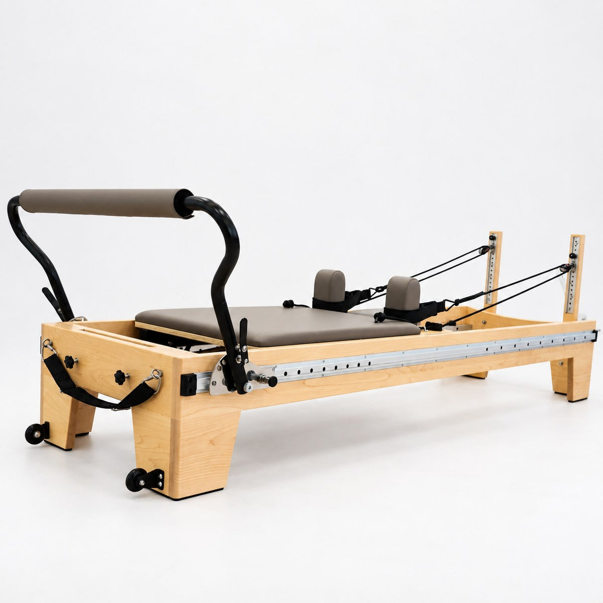 Oshun Timber Therapy Reformer in maple with taupe upholstery and a sliding footbar on its aluminum side rail