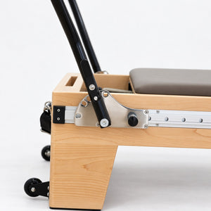 Footbar bracket with angle lever and locking knob on the aluminum rail of the Oshun Timber Therapy Reformer