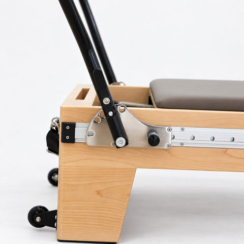 Footbar bracket with angle lever and locking knob on the aluminum rail of the Oshun Timber Therapy Reformer
