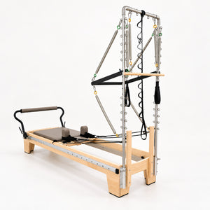 Head end of the Oshun Timber Therapy Reformer Tower Edition, with the half tower mounted to the maple frame