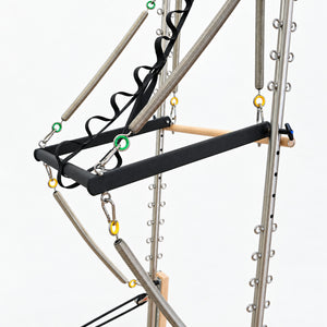 Push-through bar and maple roll-down bar on the half tower of the Oshun Timber Therapy Reformer, with color-coded springs