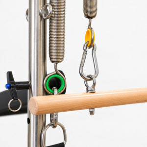 Color-coded tower springs, snap hooks and the locking pin on the half tower of the Oshun Timber Therapy Reformer
