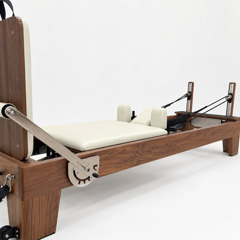 Stainless adjustable footbar, ivory carriage and shoulder rests on the solid walnut Oshun Timber Reformer