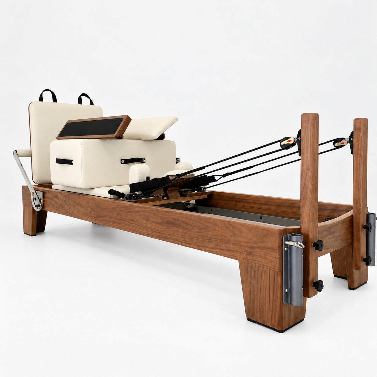 Solid walnut Oshun Timber Reformer with ivory upholstery, sitting box and jump board, seen from the rope pulley end