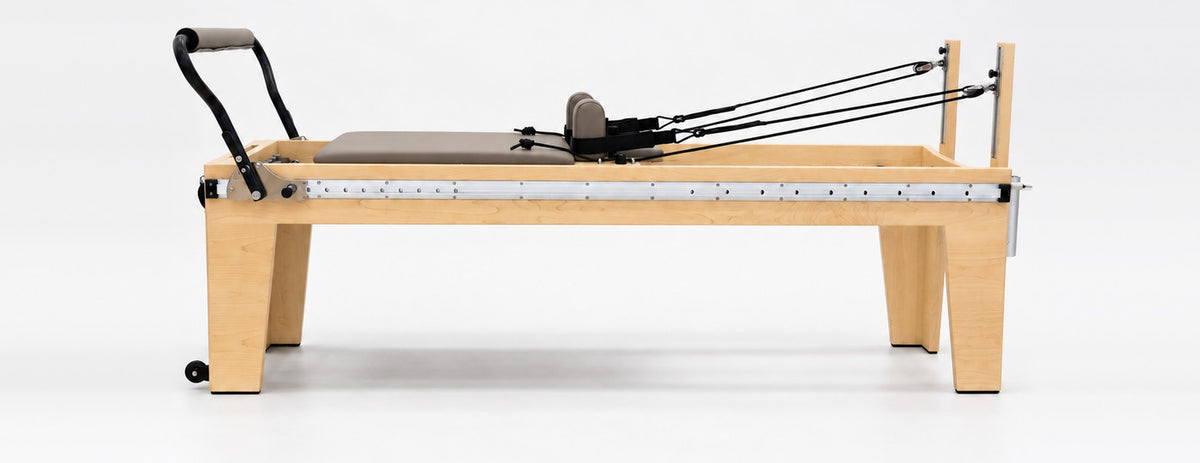 The Oshun Timber Therapy Reformer at Rehab Height, a 24 in maple frame, side view