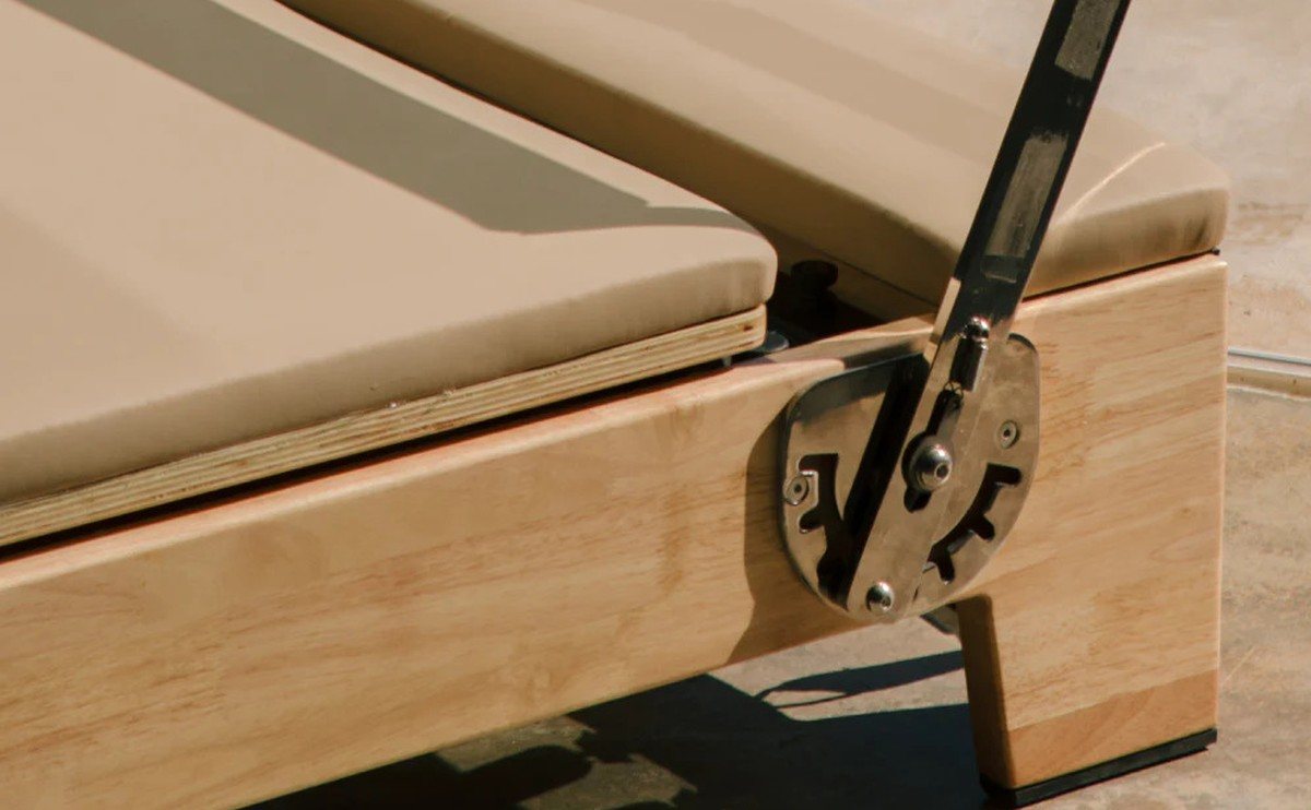 Solid wood frame and steel footbar bracket of an Oshun Timber Reformer